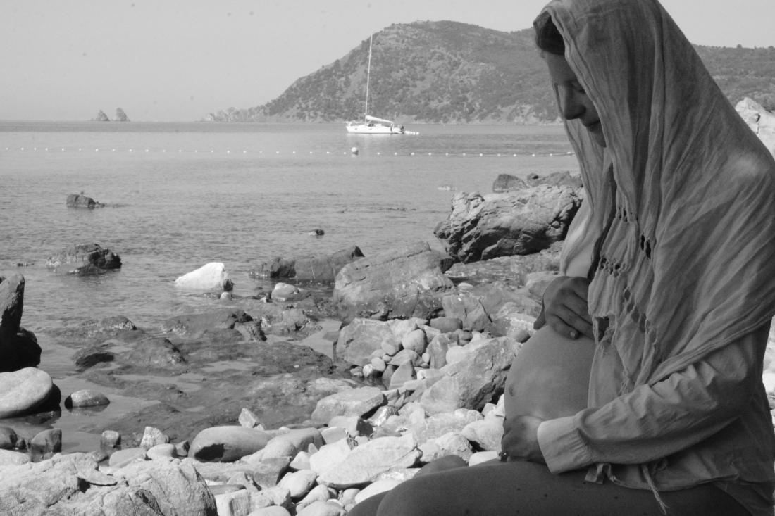 Future maman assise au bord de la mer, presqu’île de Giens