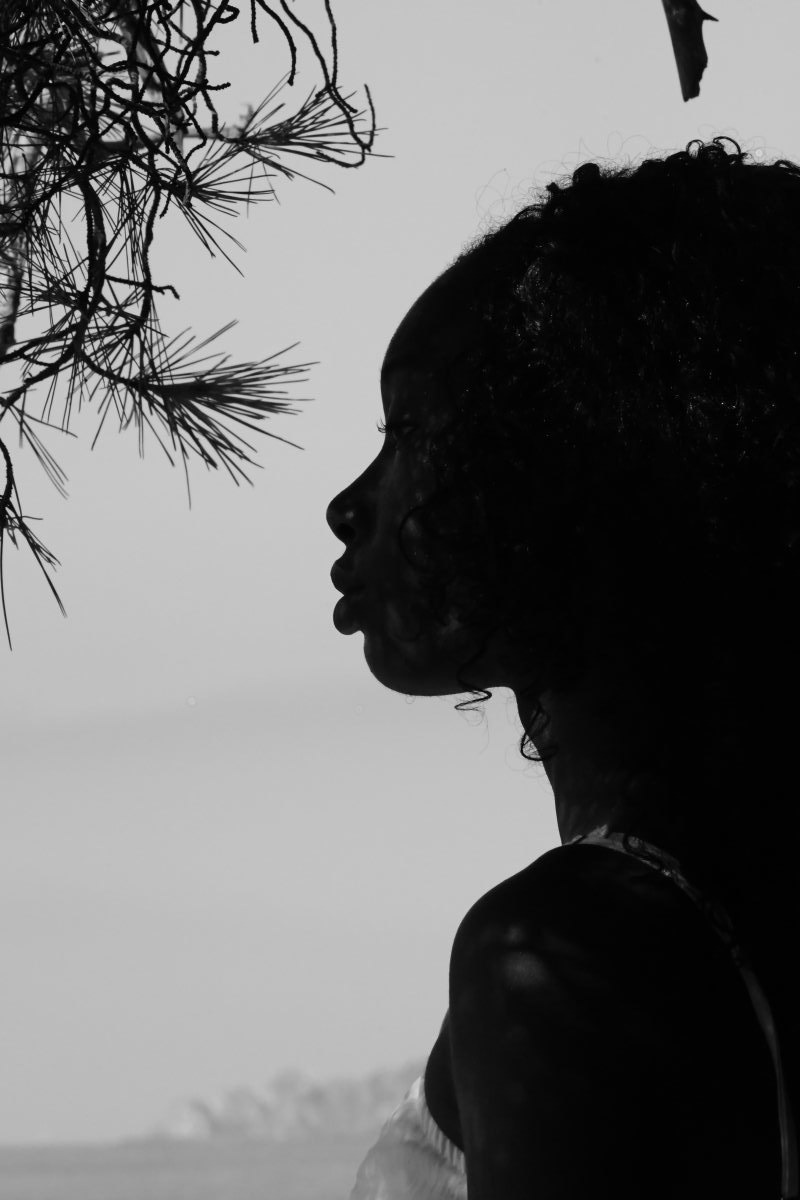 Profile of a baby sculpted by light under his mother’s gaze, black and white